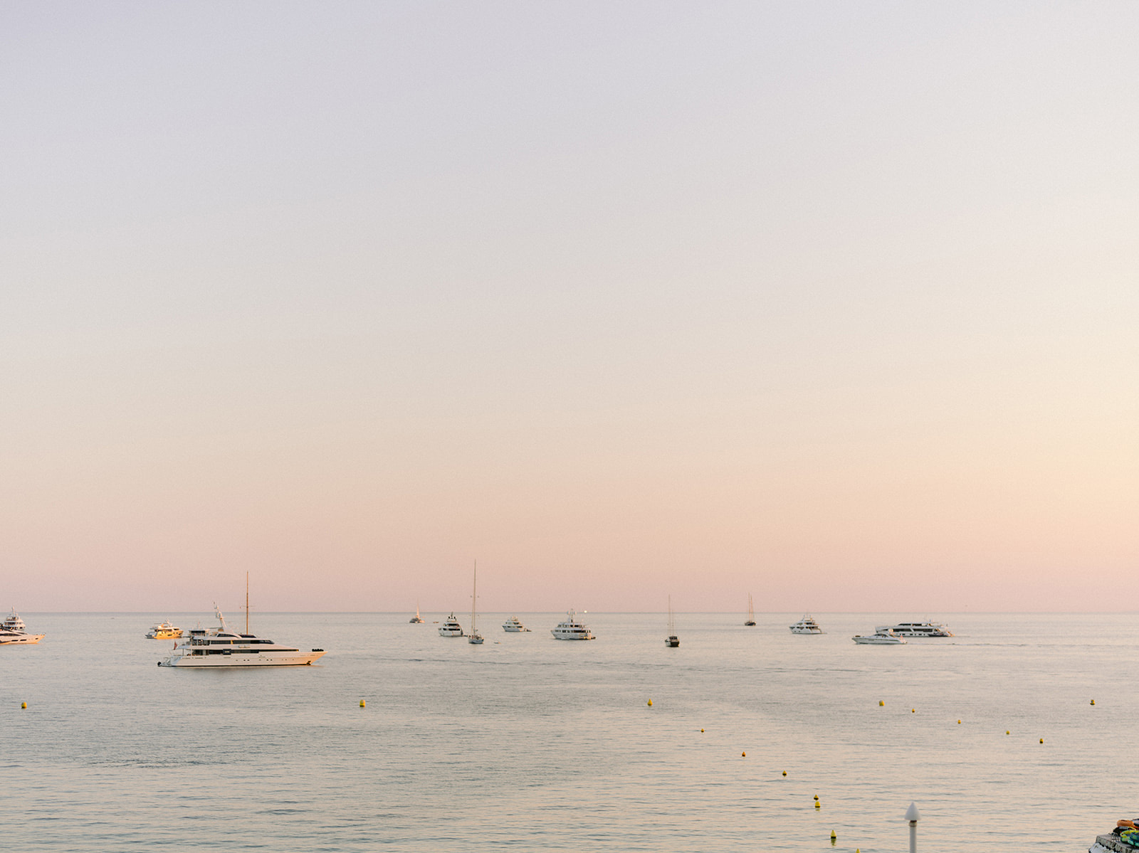 des bateaux sur la mer avec un coucher de soleil