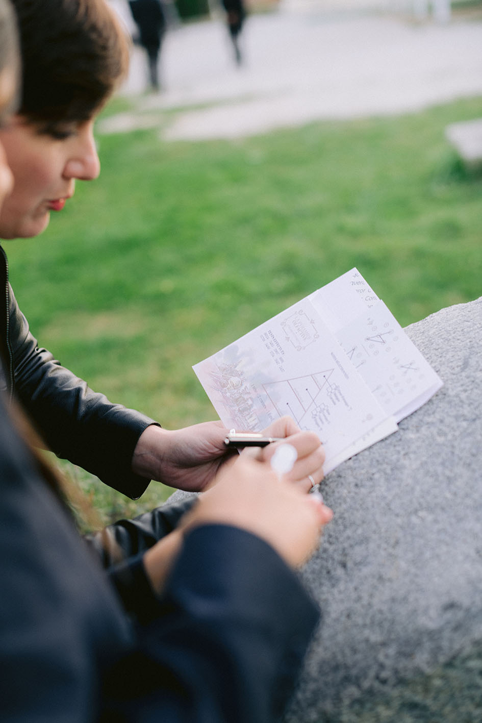 Invité résolvant une énigme imprimée Wedding Game en extérieur pendant un mariage